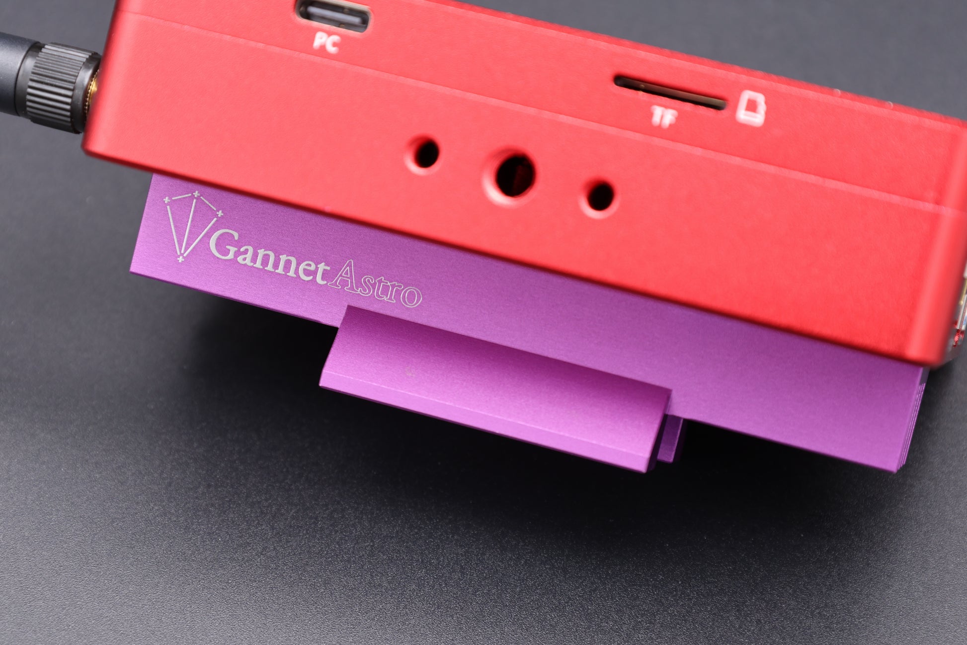 Close-up of a dedicated astrophotography computer with the Gannet Astro mounting bracket attached.  The computer is red, the bracket is purple.