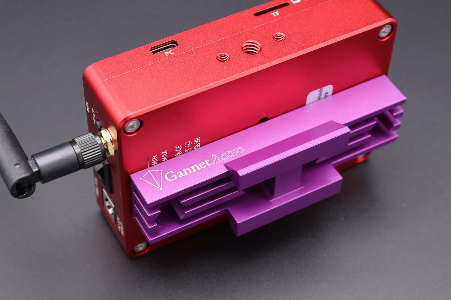 Close-up of a dedicated astrophotography computer with the Gannet Astro mounting bracket attached.  The computer is red, the bracket is purple.