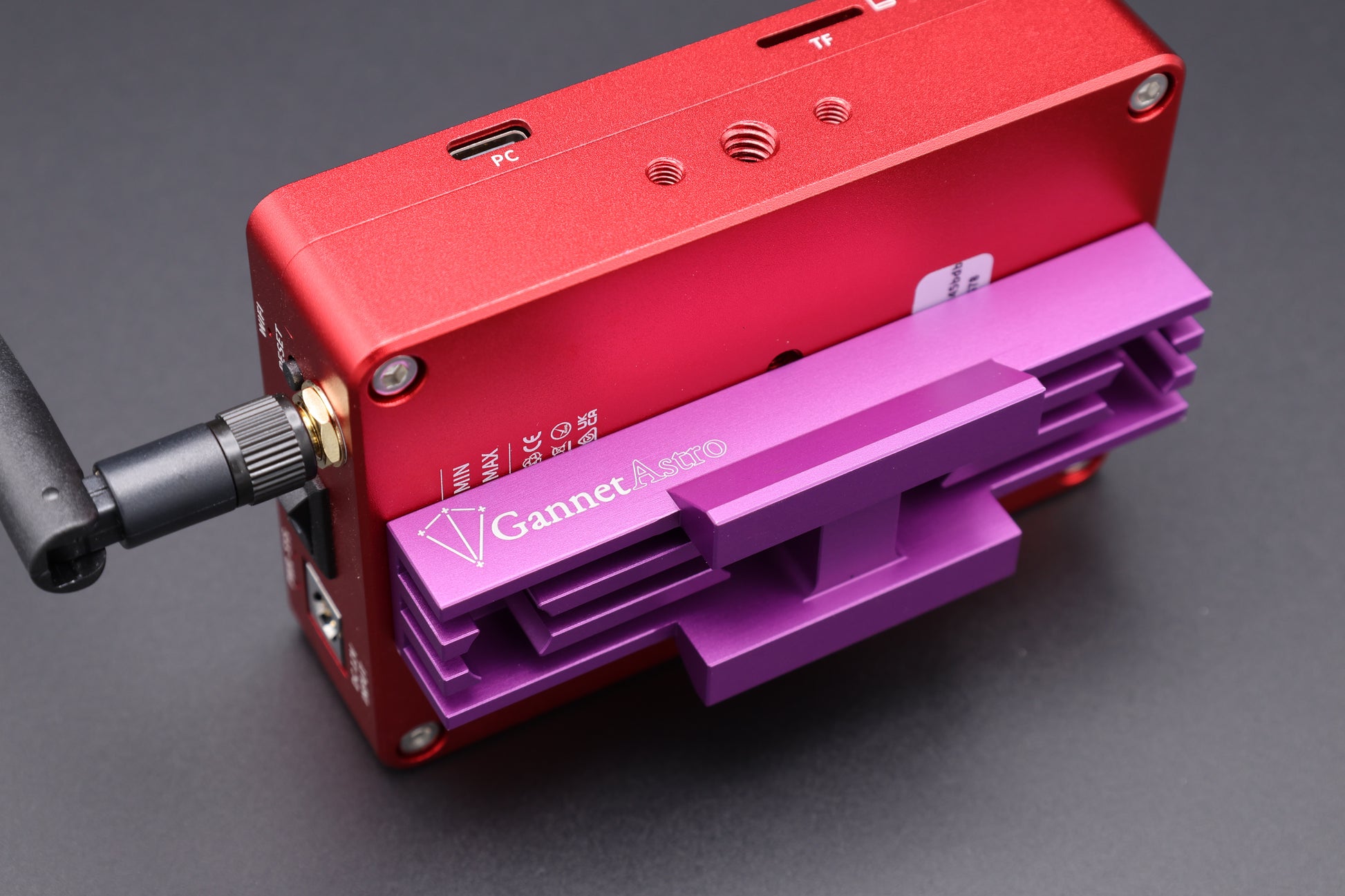 Close-up of a dedicated astrophotography computer with the Gannet Astro mounting bracket attached.  The computer is red, the bracket is purple.