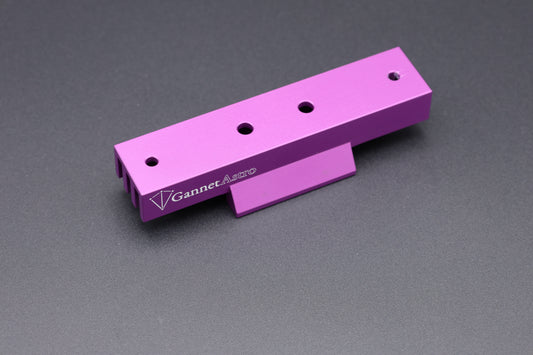 A bright purple anodized aluminum Gannet Astro mounting bracket with four screw holes and a white printed logo, shown on a dark gray textured background.
